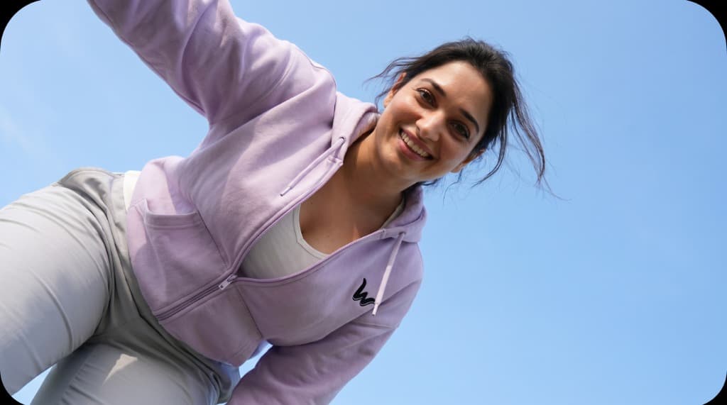 Model leaning toward camera smiling in Wamaaz lavender activewear top